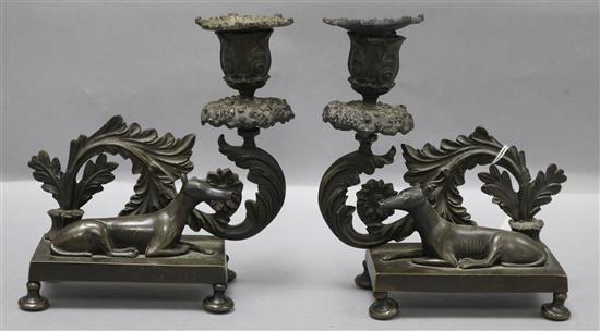 A pair of Regency cast bronze candlesticks, the bases mounted with recumbent hounds height 18cm